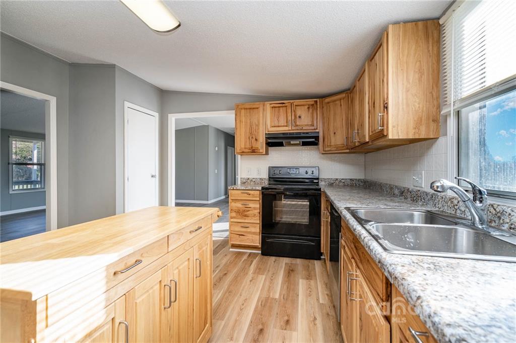 4289 Henry Dellinger Road Maiden, NC 28650 - Photo 41 of 42 a kitchen with kitchen island granite countertop a sink appliances and cabinets