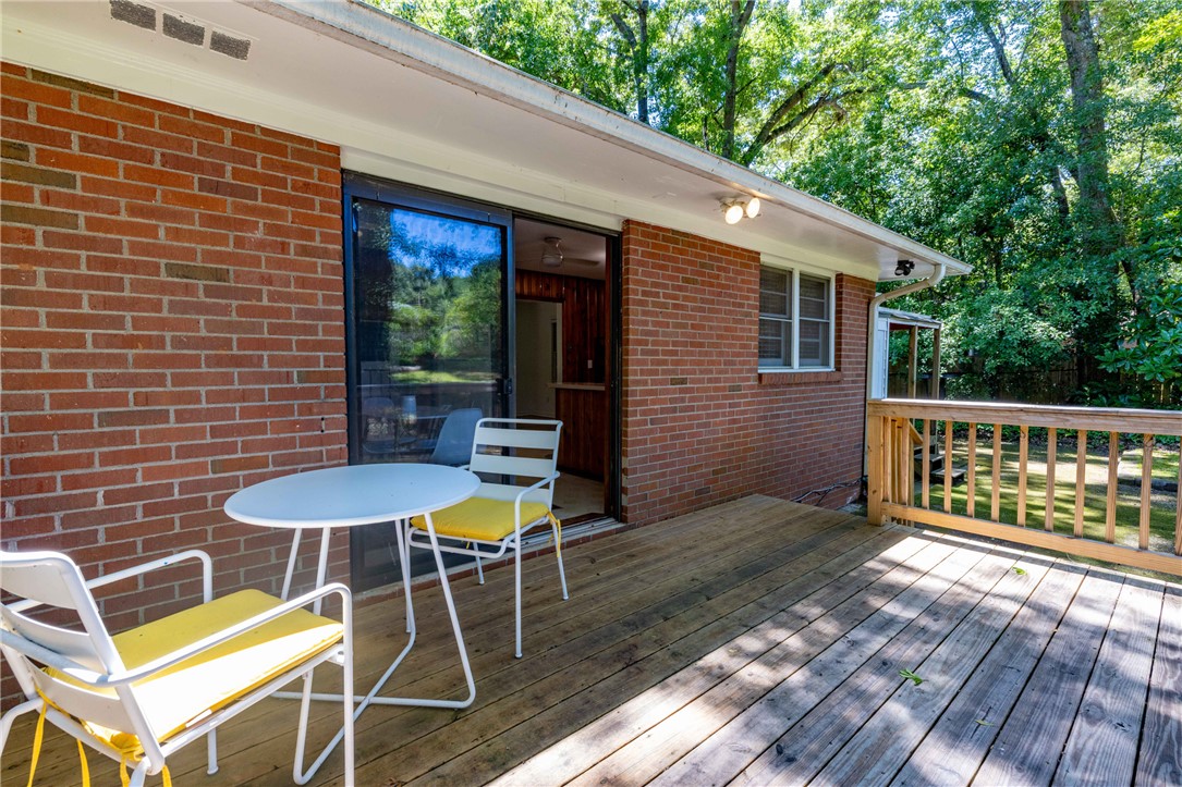 207 Brook Street Clemson, SC 29631 - Photo 25 of 39 A spacious wooden deck extends from a classic brick home, perfect for outdoor entertaining.