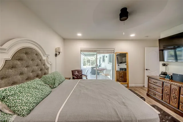 a spacious bedroom with a bed a couch and a flat tv screen on the dresser