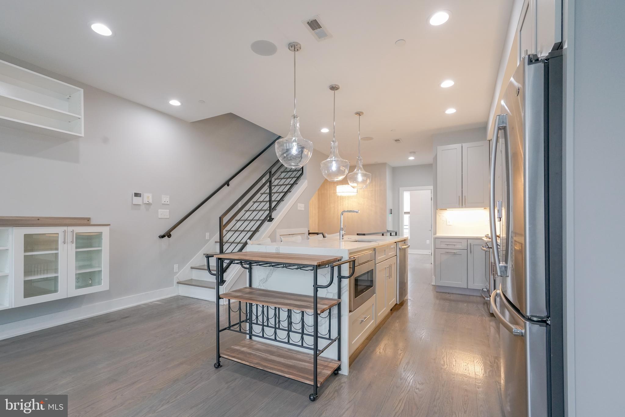 1632 K Street Northeast, Unit PH Washington, DC 20002 - Photo 16 of 69 a kitchen with kitchen island white cabinets and stainless steel appliances
