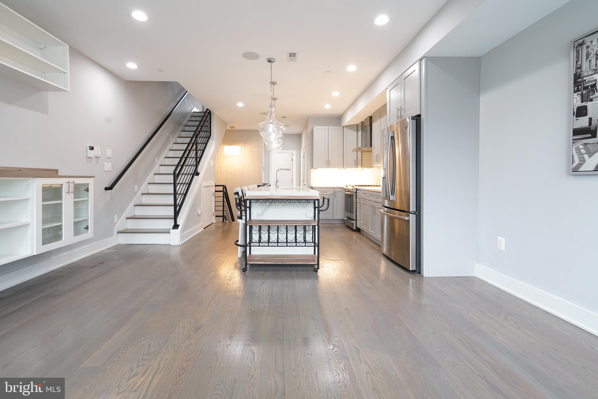 1632 K Street Northeast, Unit PH Washington, DC 20002 - Photo 17 of 69 a view of an empty room with wooden floor kitchen view and a window