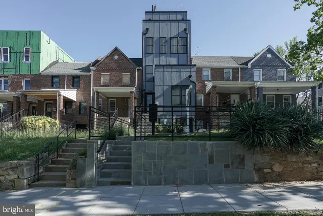 a front view of a residential apartment building with a yard