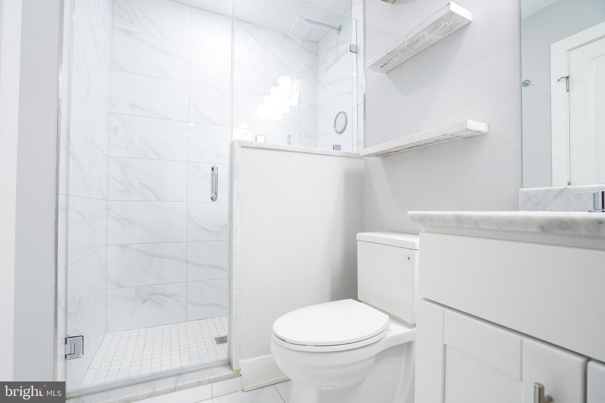 1632 K Street Northeast, Unit PH Washington, DC 20002 - Photo 55 of 69 a bathroom with a shower a toilet and a sink