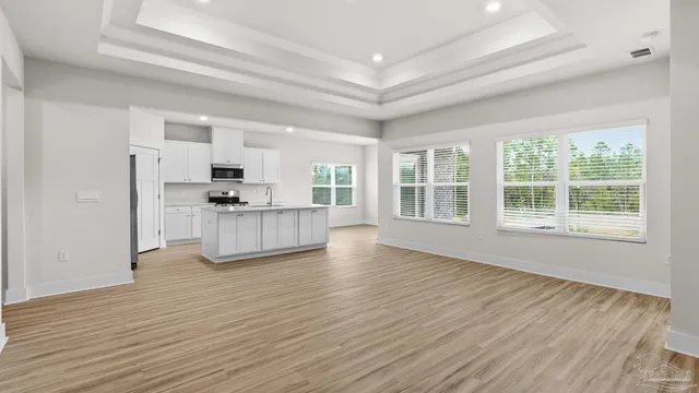 a view of kitchen with microwave a stove and wooden floor