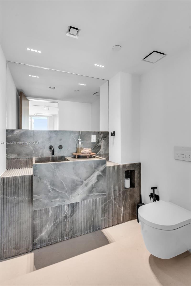 3411 Indian Creek Drive, Unit 1201 Miami Beach, FL 33140 - Photo 23 of 68 a bathroom with a sink a toilet and a mirror