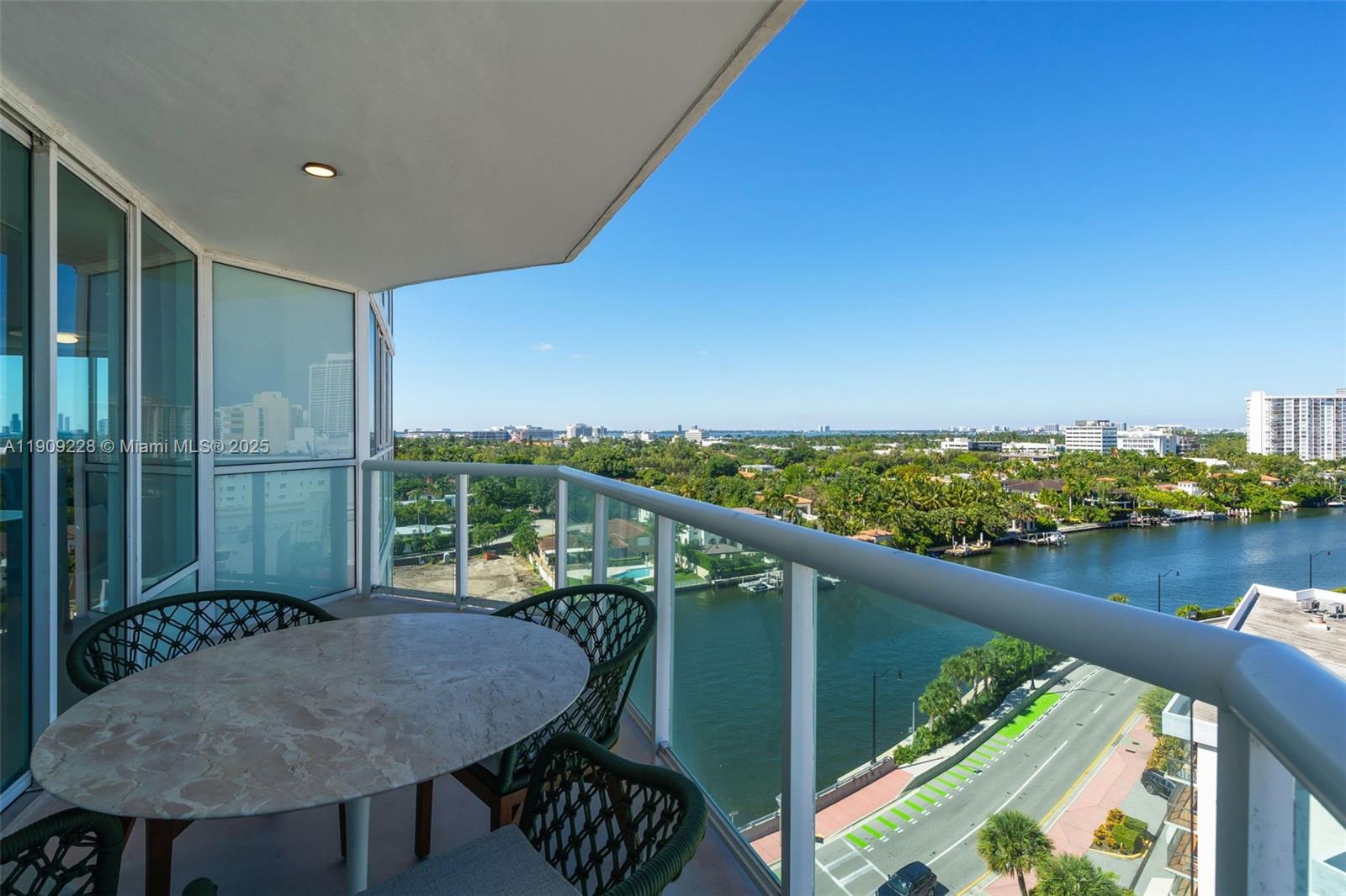 3411 Indian Creek Drive, Unit 1201 Miami Beach, FL 33140 - Photo 8 of 68 a balcony with wooden floor table and chairs