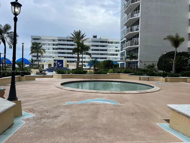 a view of swimming pool with outdoor seating and buildings in the background
