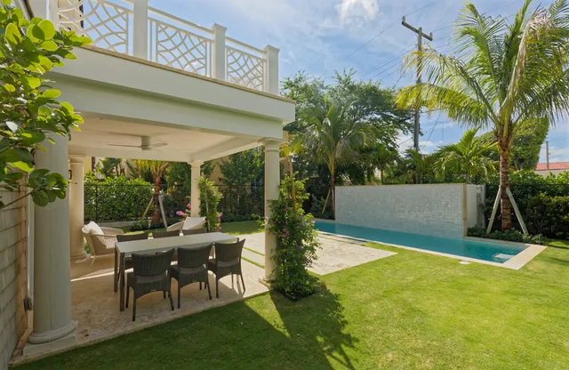 a view of a patio with table and chairs potted plants and palm tree