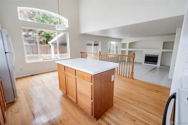 an open kitchen with wooden floor and large window
