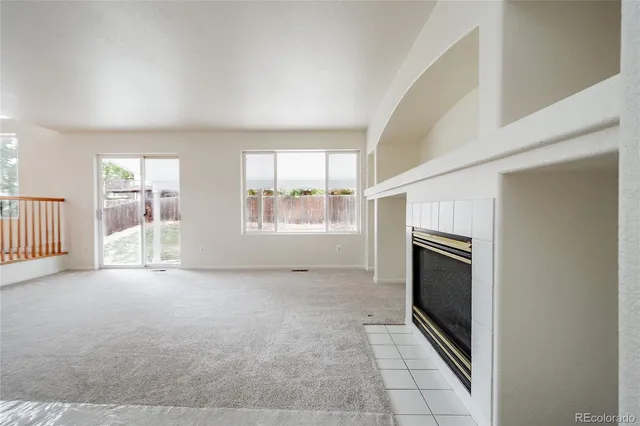 a view of a big room with windows and chandelier fan