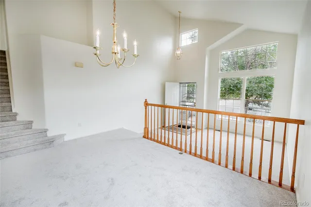 a view of a room with staircase ceiling fan and window