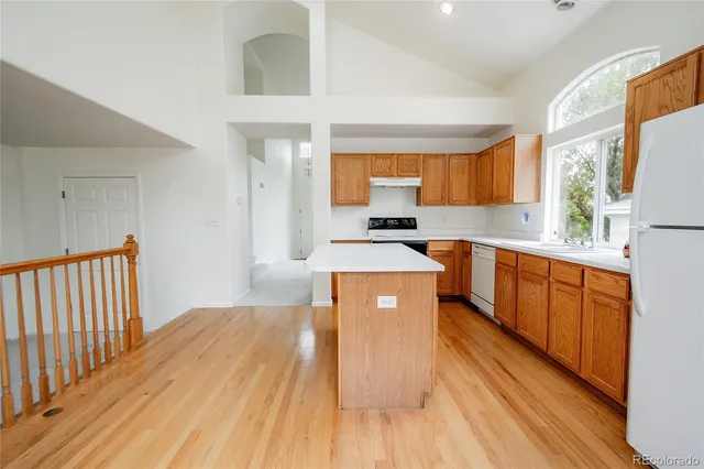 a kitchen with stainless steel appliances a refrigerator a stove a sink and white cabinets