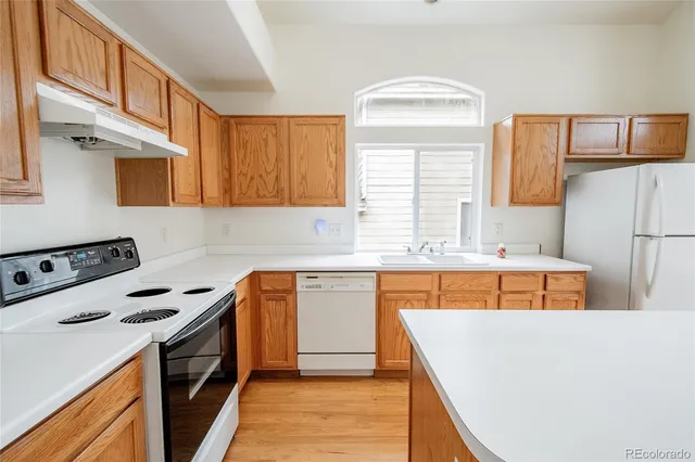 a kitchen view with wooden floor and electronic appliances