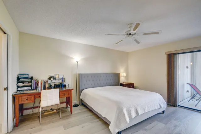 a bedroom with a bed and dresser with chair