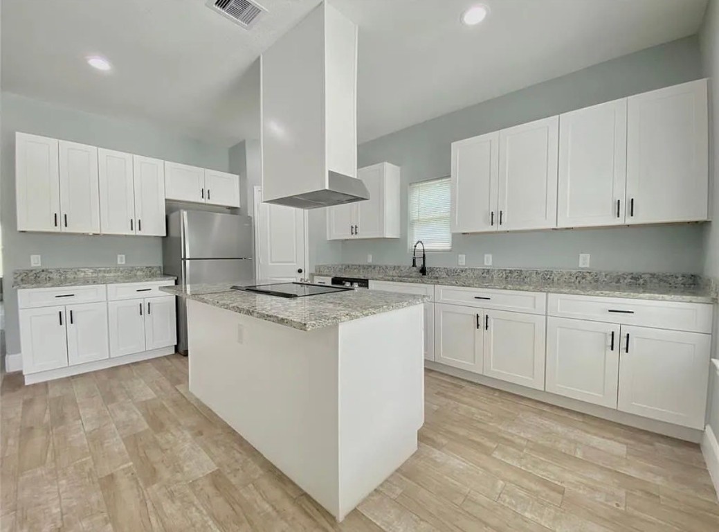 5754 Reed Road, Unit B Houston, TX 77033 - Photo 3 of 15 a kitchen with granite countertop white cabinets white stainless steel appliances with a sink and dishwasher