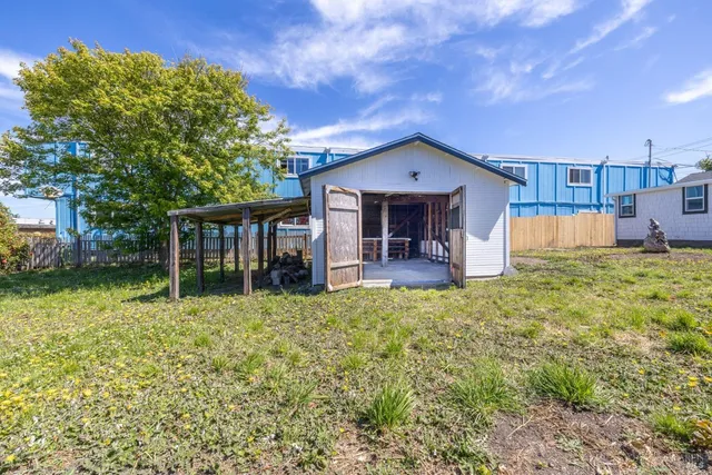 a view of a house with wooden fence next to a road