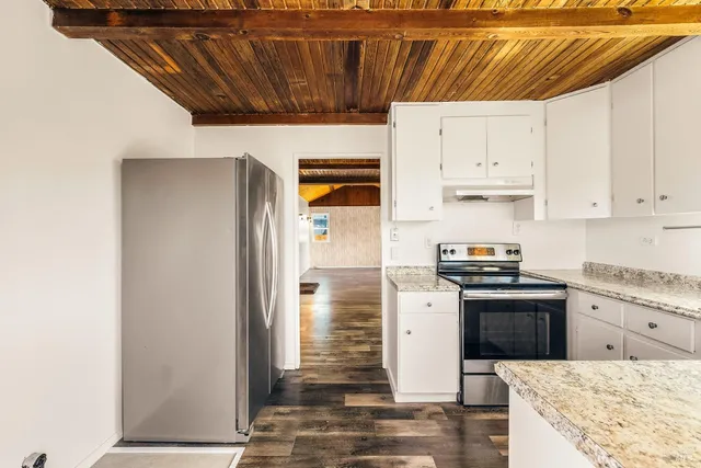 a kitchen with stainless steel appliances granite countertop a refrigerator and a stove