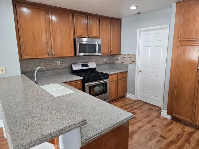 a kitchen with stainless steel appliances granite countertop a sink stove and microwave