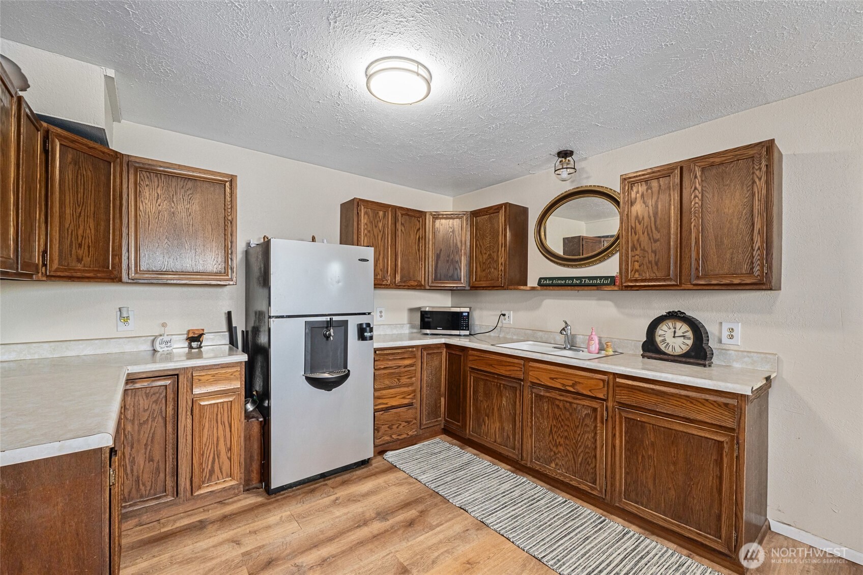 93 Warren Road Tonasket, WA 98855 - Photo 12 of 31 a kitchen with stainless steel appliances granite countertop a stove a sink dishwasher and a microwave oven with cabinets