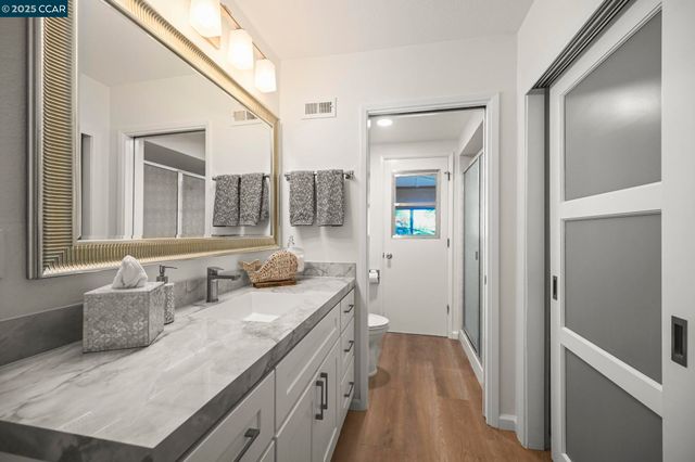 a en suite bathroom with a granite countertop sink and a mirror