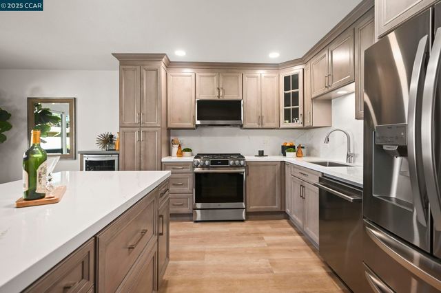 a kitchen with stainless steel appliances granite countertop a stove refrigerator and a sink