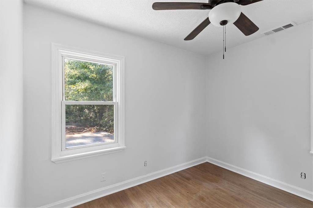 1347 Westmont Road Southwest Atlanta, GA 30311 - Photo 16 of 26 a view of a room with wooden floor fan and windows