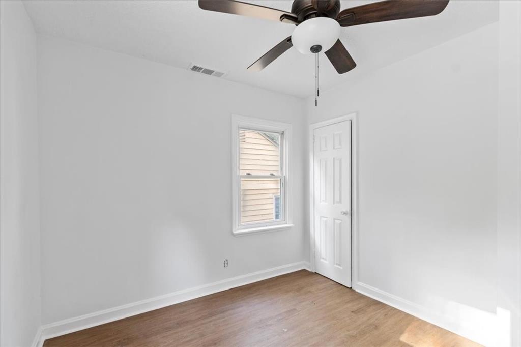 1347 Westmont Road Southwest Atlanta, GA 30311 - Photo 17 of 26 an empty room with wooden floor ceiling fan and window