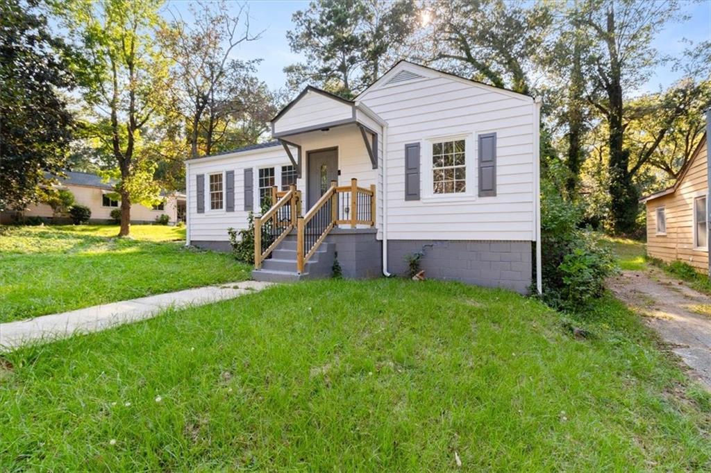 1347 Westmont Road Southwest Atlanta, GA 30311 - Photo 20 of 26 a front view of a house with a garden and trees