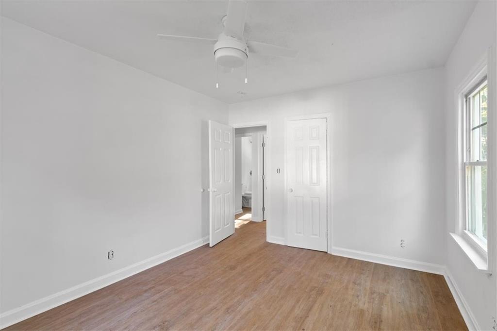 1347 Westmont Road Southwest Atlanta, GA 30311 - Photo 8 of 26 an empty room with wooden floor and windows
