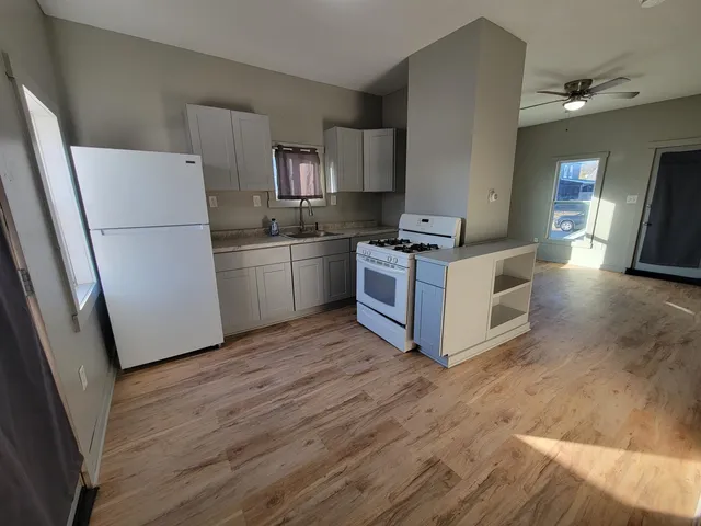 a kitchen with stainless steel appliances granite countertop a stove a refrigerator and a granite counter tops with wooden floors