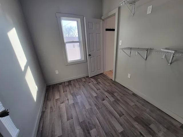 a view of a room with wooden floor and window
