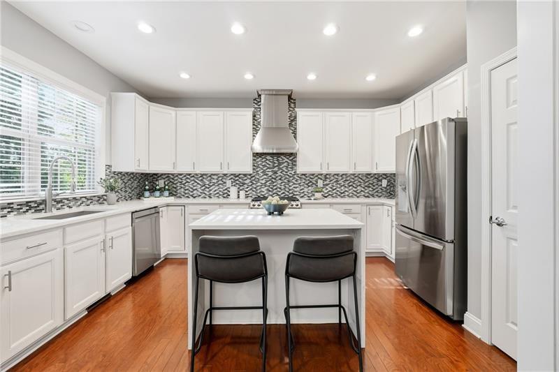 3655 East Paces Walk Atlanta, GA 30326 - Photo 5 of 31 a kitchen with stainless steel appliances granite countertop a stove a sink a refrigerator and white cabinets with wooden floor