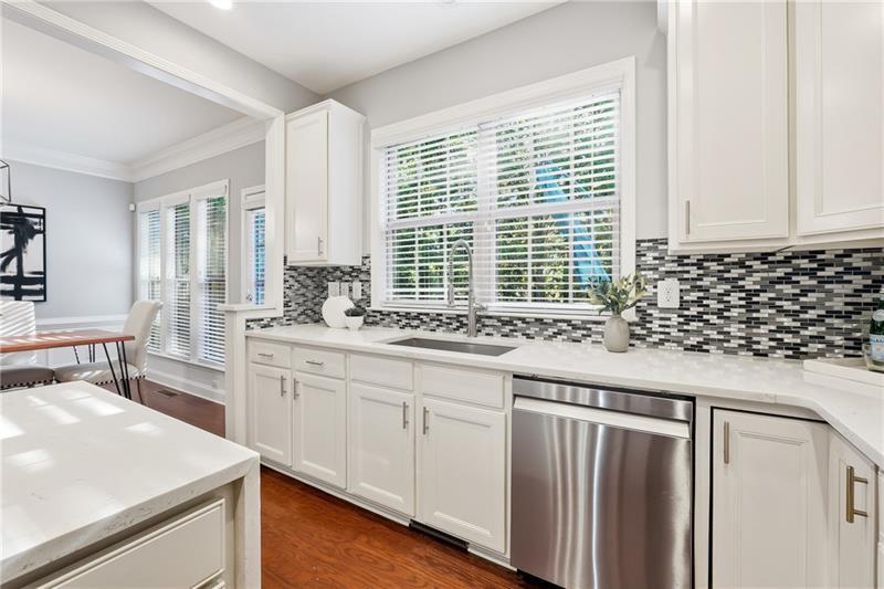 3655 East Paces Walk Atlanta, GA 30326 - Photo 7 of 31 a kitchen with granite countertop a sink and a white wooden cabinets