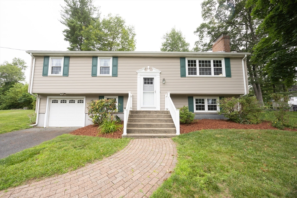 6 Clearview Drive Milford, MA 01757 - Photo 1 of 42 a front view of a house with a garden and trees