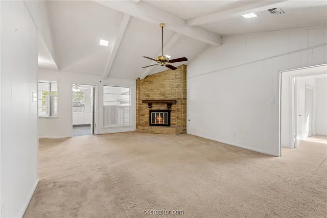 an empty room with kitchen and windows