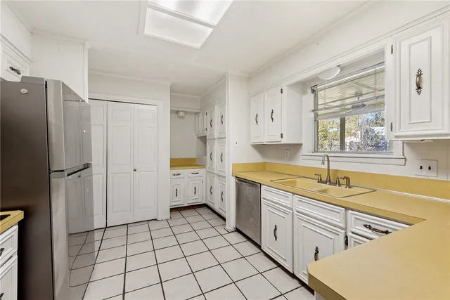 a kitchen with white cabinets a refrigerator and a stove