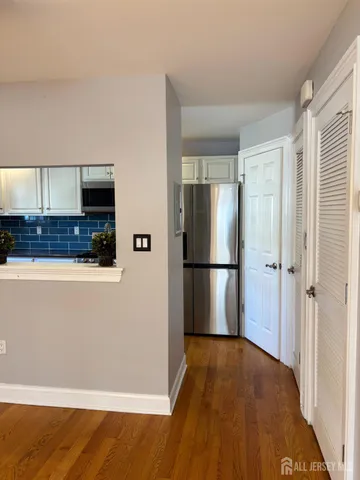 a view of a kitchen with a sink and dishwasher a stove top oven with wooden floor