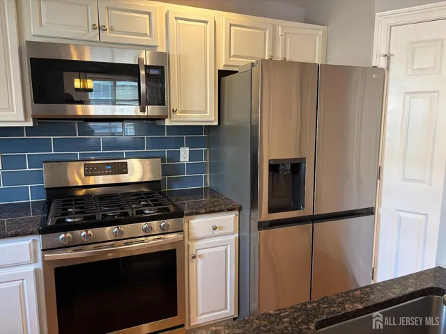 a view of a kitchen with wooden floor and a refrigerator
