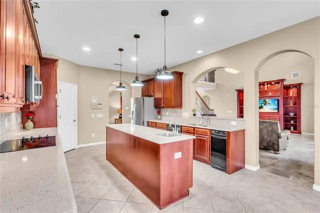 a large kitchen with stainless steel appliances granite countertop a stove and cabinets