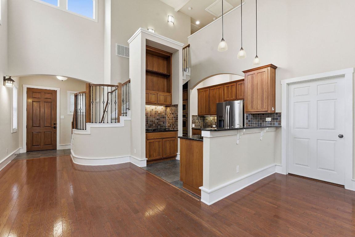 2506 Enfield Road, Unit B Austin, TX 78703 - Photo 11 of 40 Kitchen with brown cabinets, a peninsula, arched walkways, decorative light fixtures, and a high ceiling