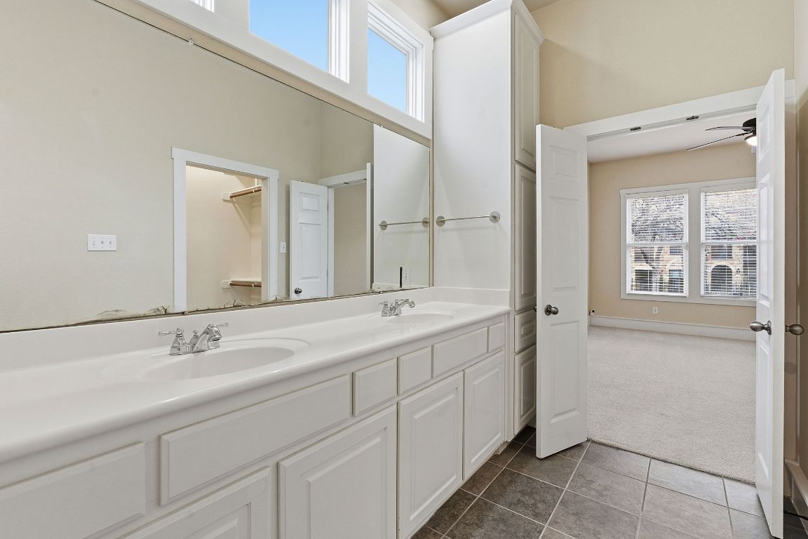 2506 Enfield Road, Unit B Austin, TX 78703 - Photo 23 of 40 Bathroom with healthy amount of natural light, double vanity, dark carpet, a towering ceiling, and a spacious closet
