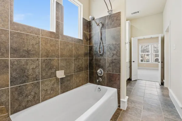 a bathroom with a tub shower and sink