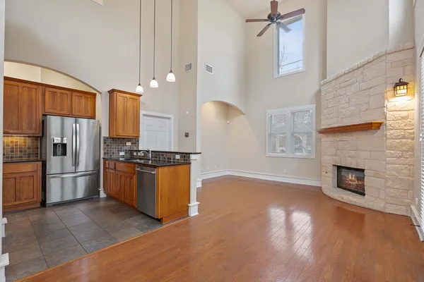 an empty room with wooden floor fireplace and windows