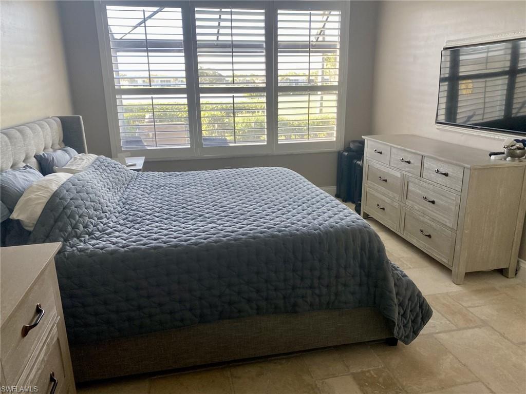 9035 Spring Run Boulevard Estero, FL 34135 - Photo 6 of 9 Bedroom with stone tile flooring