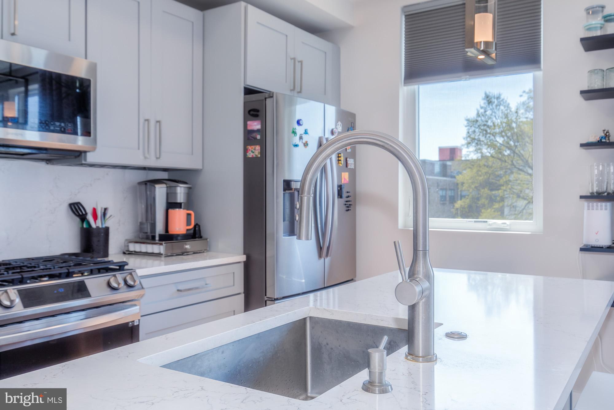 1444 Harvard Street Northwest, Unit 302 Washington, DC 20009 - Photo 19 of 50 a kitchen with stainless steel appliances granite countertop a refrigerator sink and stove