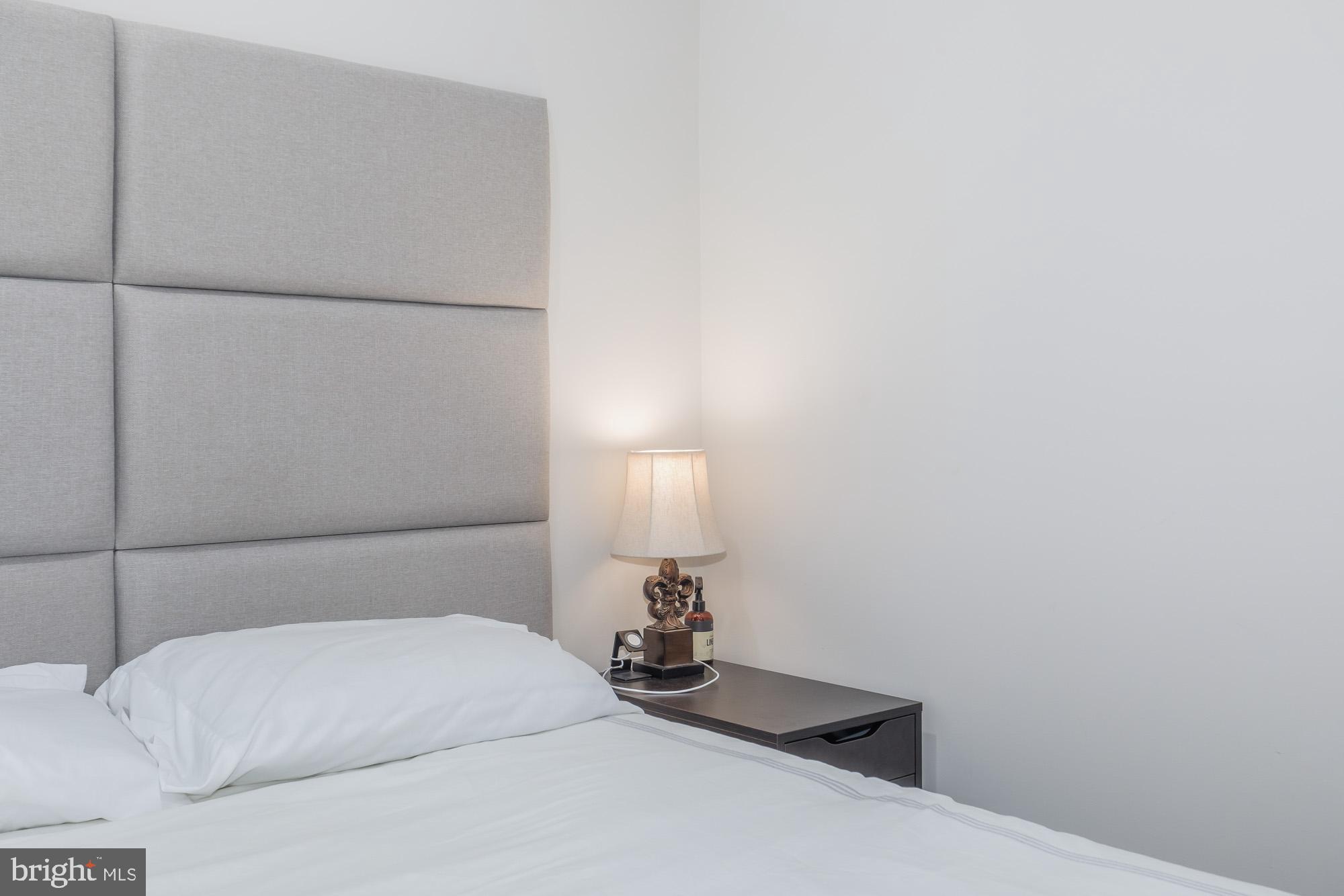 1444 Harvard Street Northwest, Unit 302 Washington, DC 20009 - Photo 24 of 50 a bedroom with a bed and a lamp