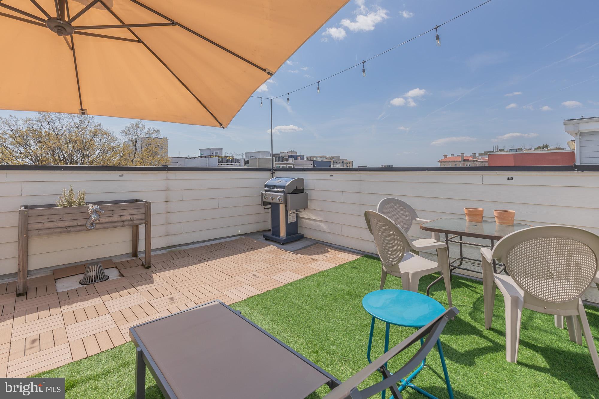 1444 Harvard Street Northwest, Unit 302 Washington, DC 20009 - Photo 39 of 50 a view of a patio with table and chairs under an umbrella