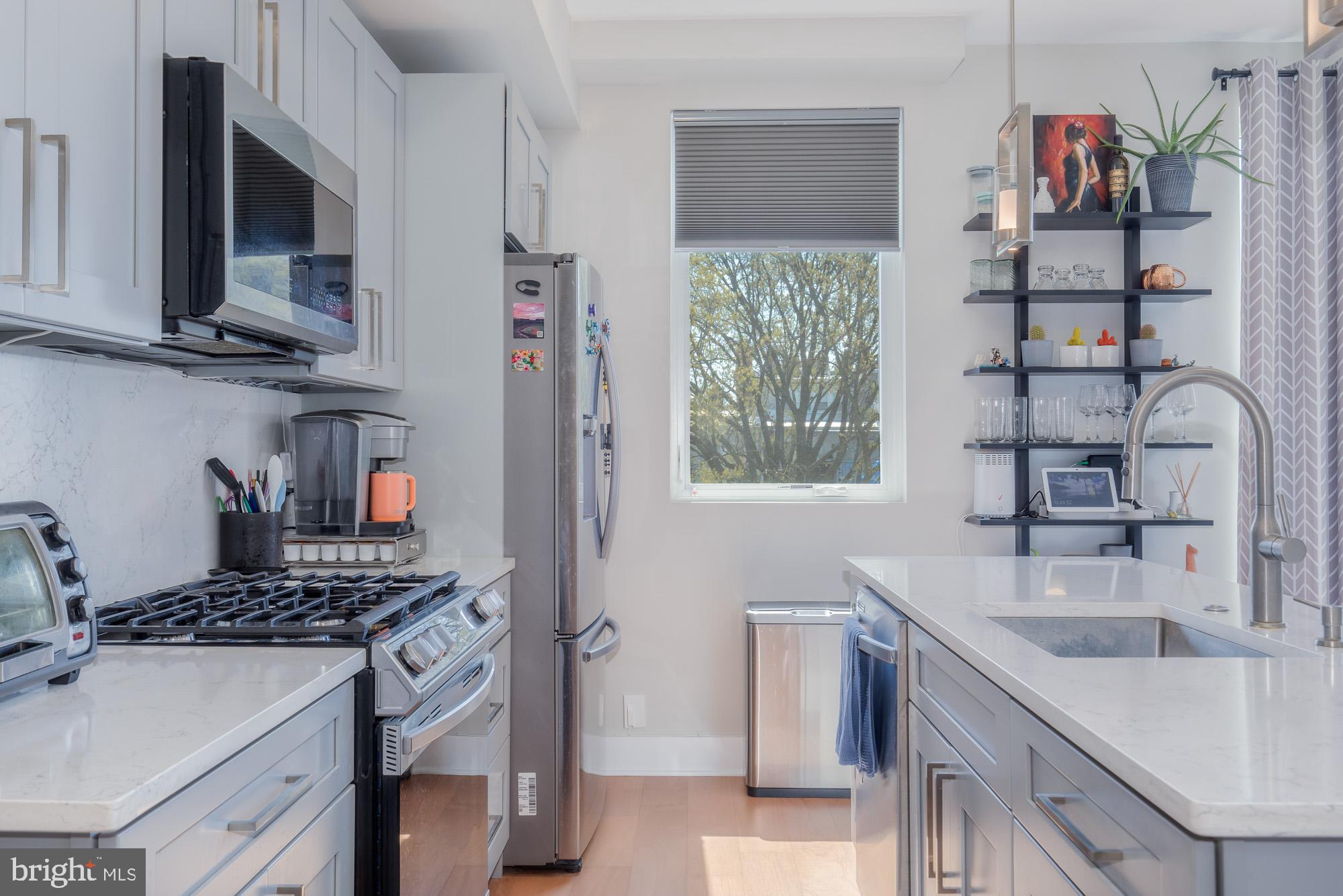 1444 Harvard Street Northwest, Unit 302 Washington, DC 20009 - Photo 10 of 50 a kitchen with stainless steel appliances granite countertop a sink stove and cabinets