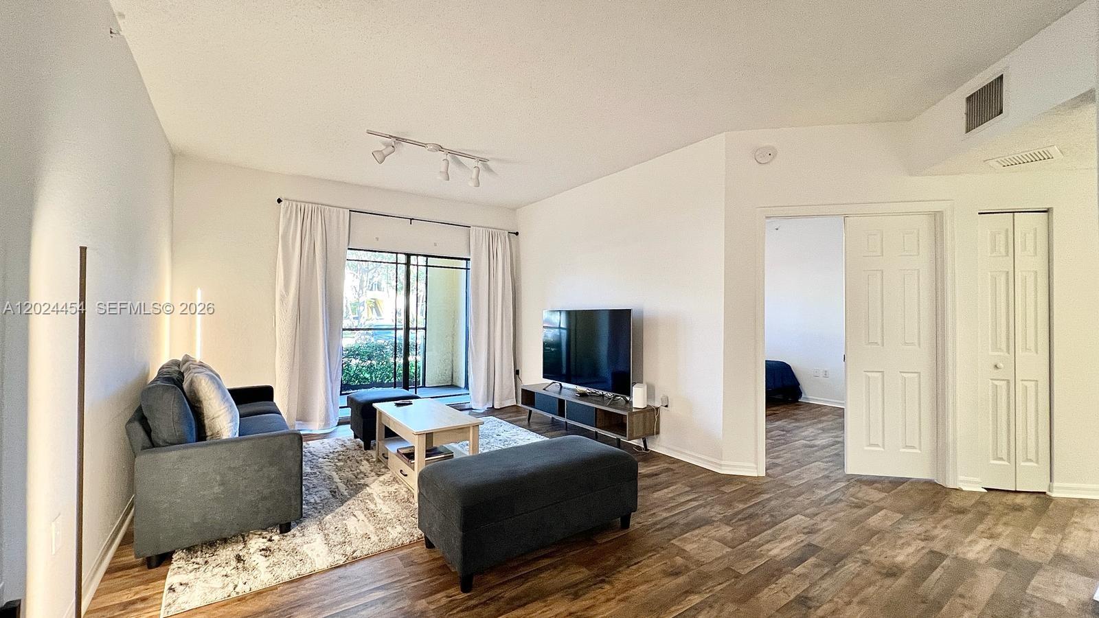 2727 Anzio Court, Unit 106 Palm Beach Gardens, FL 33410 - Photo 4 of 43 a living room with furniture and a flat screen tv