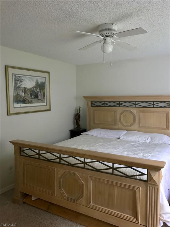 2214 Arbour Walk Circle, Unit 2012 Naples, FL 34109 - Photo 13 of 17 a bedroom with a bed and ceiling fan